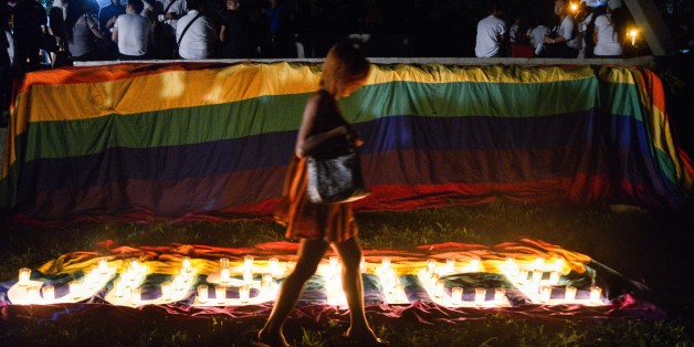 A transgender Filipino walks across the lit candles formed "